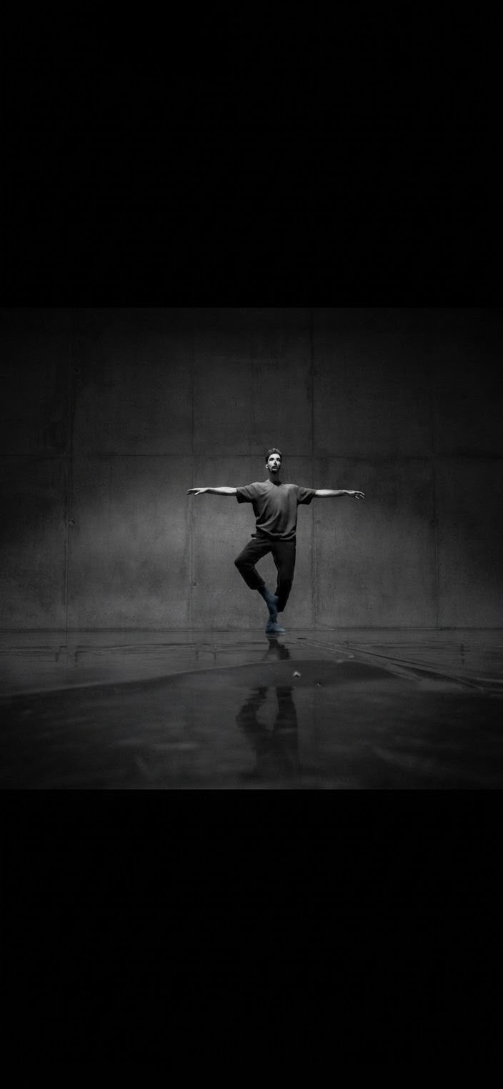 Xavier Abella danse devant un mur sombre, reflété par le sol